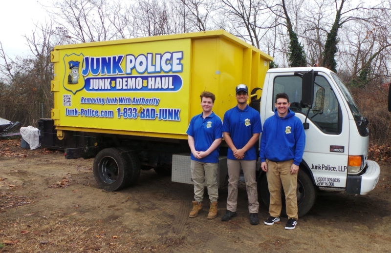 Junk Police crew smiling in front of their truck
