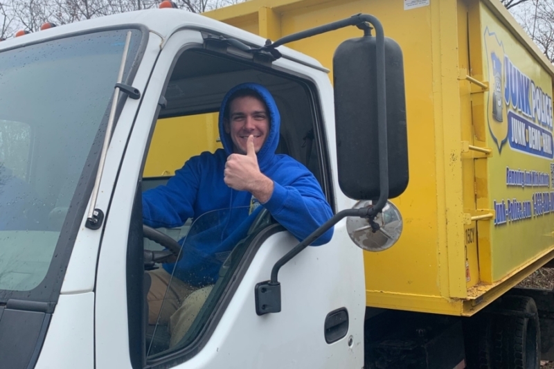 Junk Police professional smiling in the truck while providing junk removal services in Delaware County