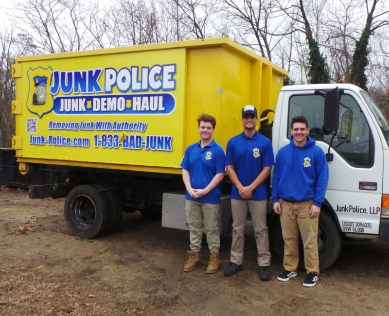 Junk Police crew smiling in front of the truck before basement cleanout services