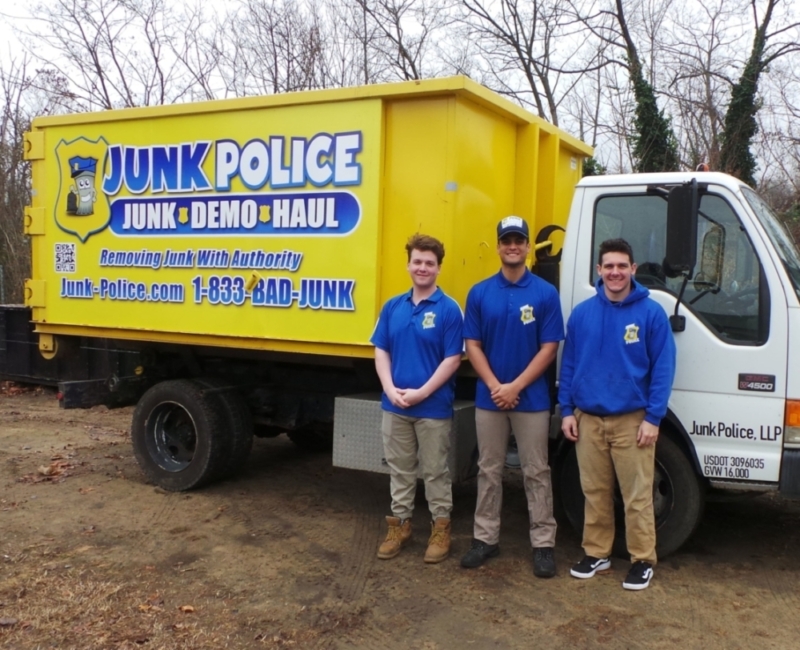 Junk Police crew smiling next to the truck